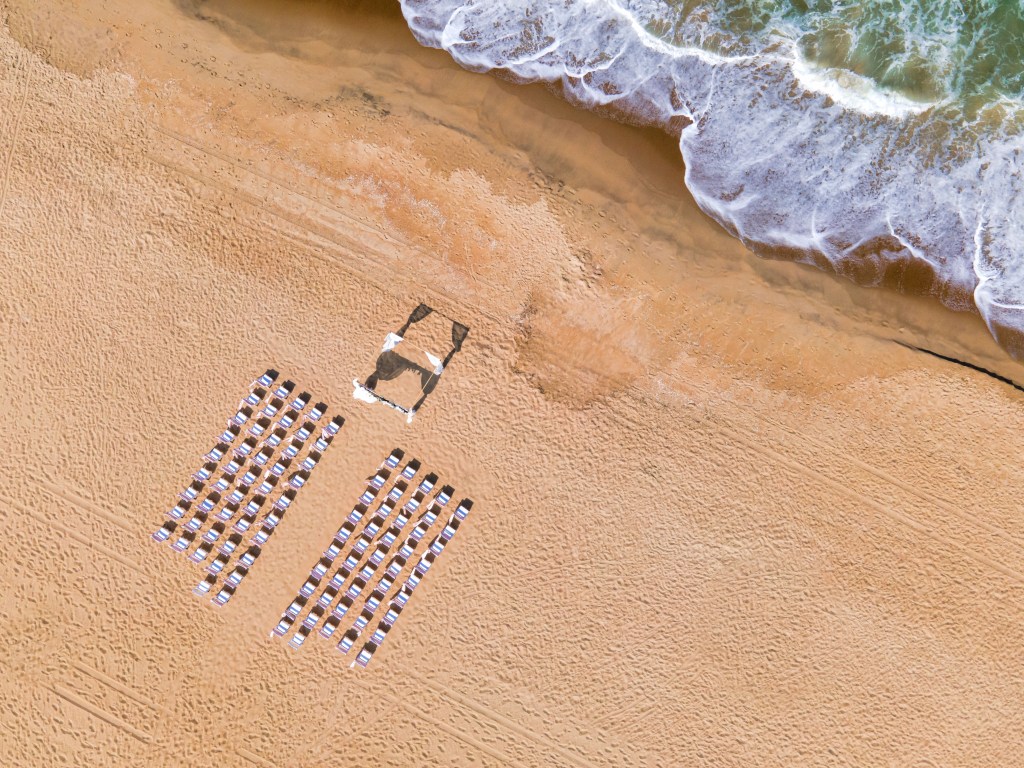 (beachside numbered chairs and uncovered area near the ocean)